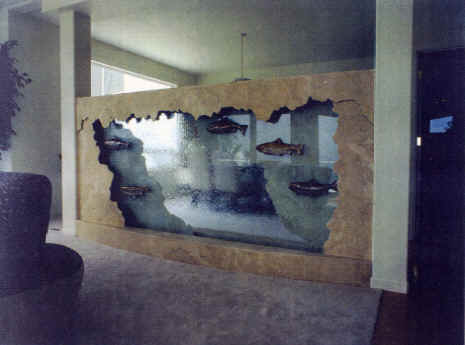 Tacoma, WA residence.12 ft x 6 ft tall two sided room divided glass 5 racue glazed salmon mounted on glass with water passing behind them, fractured travertine marble on both sides, basin integrated into floor, lighting in valance, existing home, remote pump.