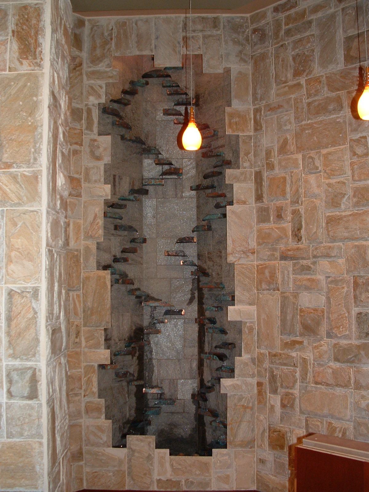 Tulalup Casino, WA. 5 ft x 14 ft tall rustic handmade copper trays spill water back and forth making its way to the basin with a very nice sound and all is mounted on an Idaho quartz backdrop with a lime stone for ground lighting within valance, new construction.